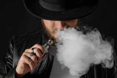 Adam vaping mod Buhar siyah stüdyo arka plan adlı parçasıyla birlikte kullanılmalıdır. Sakallı adam e-sigara tütün çıkmak için. Buharı ve alternatif nikotin ücretsiz Sigara kavramı