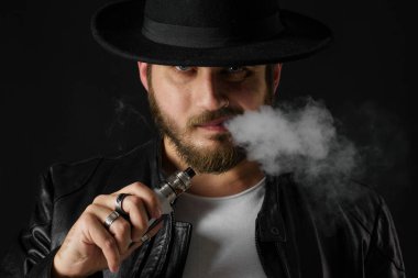 Adam vaping mod Buhar siyah stüdyo arka plan adlı parçasıyla birlikte kullanılmalıdır. Sakallı adam e-sigara tütün çıkmak için. Buharı ve alternatif nikotin ücretsiz Sigara kavramı