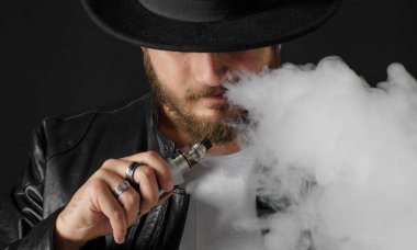 Adam vaping mod Buhar siyah stüdyo arka plan adlı parçasıyla birlikte kullanılmalıdır. Sakallı adam e-sigara tütün çıkmak için. Buharı ve alternatif nikotin ücretsiz Sigara kavramı