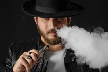 Adam vaping mod Buhar siyah stüdyo arka plan adlı parçasıyla birlikte kullanılmalıdır. Sakallı adam e-sigara tütün çıkmak için. Buharı ve alternatif nikotin ücretsiz Sigara kavramı