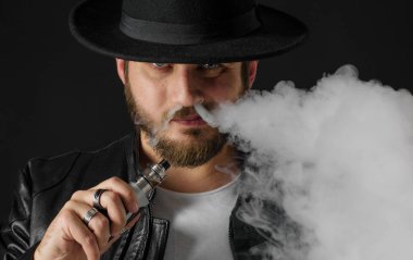 Adam vaping mod Buhar siyah stüdyo arka plan adlı parçasıyla birlikte kullanılmalıdır. Sakallı adam e-sigara tütün çıkmak için. Buharı ve alternatif nikotin ücretsiz Sigara kavramı