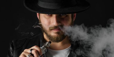Adam vaping mod Buhar siyah stüdyo arka plan adlı parçasıyla birlikte kullanılmalıdır. Sakallı adam e-sigara tütün çıkmak için. Buharı ve alternatif nikotin ücretsiz Sigara kavramı