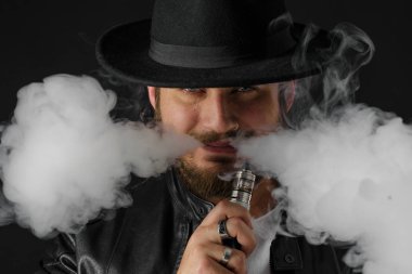Adam vaping mod Buhar siyah stüdyo arka plan adlı parçasıyla birlikte kullanılmalıdır. Sakallı adam e-sigara tütün çıkmak için. Buharı ve alternatif nikotin ücretsiz Sigara kavramı