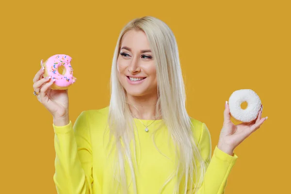 Mulher Escolhendo Entre Dois Donuts Com Polvilhas Fundo Amarelo Conceito — Fotografia de Stock