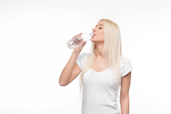 Healthy blond woman holding and drink glass of pure water on isolated white background