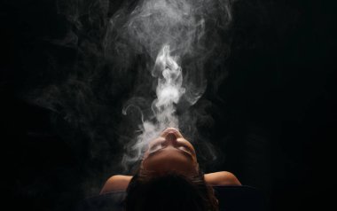 Kızıl saçlı kadın vaping elektronik sigara duman siyah arka plan ile. Genç kadın e-sigara tütün çıkmak için. Buharı ve alternatif nikotin ücretsiz Sigara kavramı kopya alanı 
