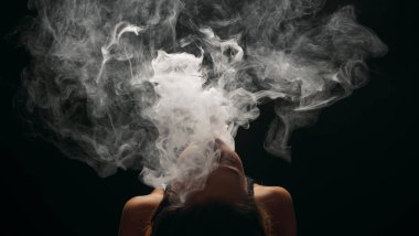 Kızıl saçlı kadın vaping elektronik sigara duman siyah arka plan ile. Genç kadın e-sigara tütün çıkmak için. Buharı ve alternatif nikotin ücretsiz Sigara kavramı kopya alanı 
