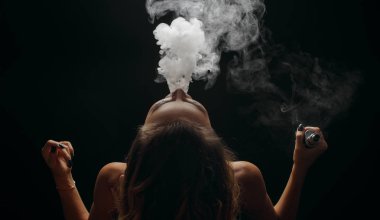 Kızıl saçlı kadın vaping elektronik sigara duman siyah arka plan ile. Genç kadın e-sigara tütün çıkmak için. Buharı ve alternatif nikotin ücretsiz Sigara kavramı kopya alanı 