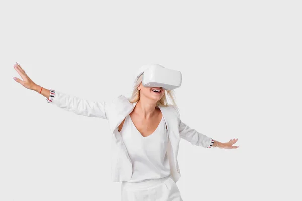 金发碧眼的女人在白色套房与虚拟现实护目镜 演播室射击在白色背景 — 图库照片