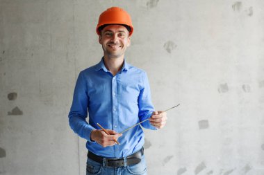 Memnun inşaat işçisi foreman bir mezura yapım aşamasında bir evde bir duvar parametrenin ölçer. Onarım hazırlık ve gerçekleşen çalışma doğruluğunu inceler