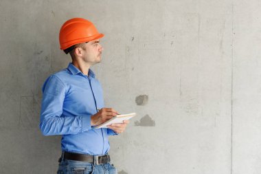 Defter üzerinde inşaat danışman yazar duvara yakın. Yakışıklı Foreman'ın içinde clipboard not alma. İnşaat Müfettiş denetimi yeni nesne