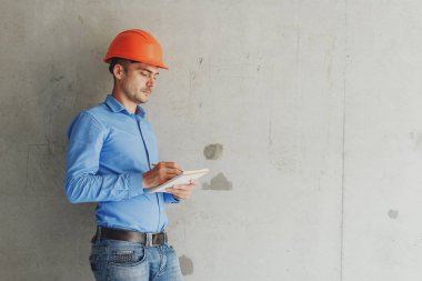 Defter üzerinde inşaat danışman yazar duvara yakın. Yakışıklı Foreman'ın içinde clipboard not alma. İnşaat Müfettiş denetimi yeni nesne