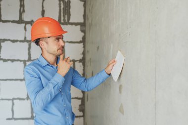 Defter üzerinde inşaat danışman yazar duvara yakın. Yakışıklı Foreman'ın içinde clipboard not alma. İnşaat Müfettiş denetimi yeni nesne