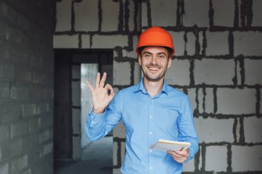 Defter üzerinde inşaat danışman yazar duvara yakın. Yakışıklı Foreman'ın içinde clipboard not alma. İnşaat Müfettiş denetimi yeni nesne
