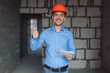 Defter üzerinde inşaat danışman yazar duvara yakın. Yakışıklı Foreman'ın içinde clipboard not alma. İnşaat Müfettiş denetimi yeni nesne