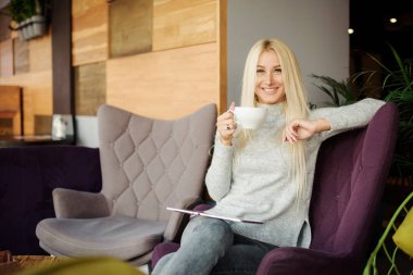 Kafedeki kadına pencerenin oturur ve zevk ile kahve içer