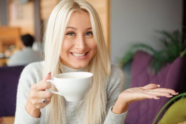 Neşeli mutlu sarışın kadın sabah kahve içme ve gülümseyen Cafe 