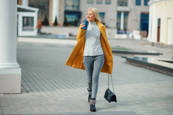 Joven Mujer Rubia Con Abrigo Amarillo Brillante Con Una Taza — Foto de Stock