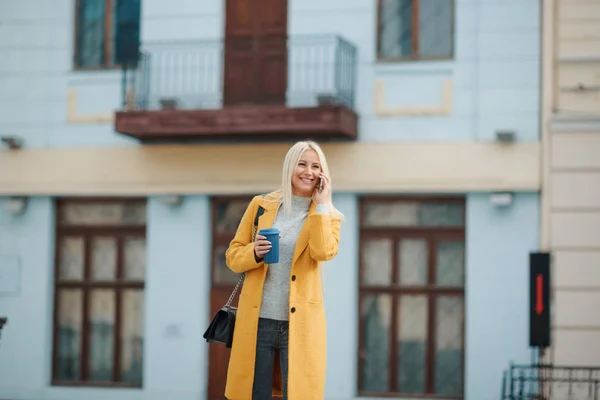 Feliz Joven Rubia Con Abrigo Amarillo Brillante Está Hablando Por — Foto de Stock