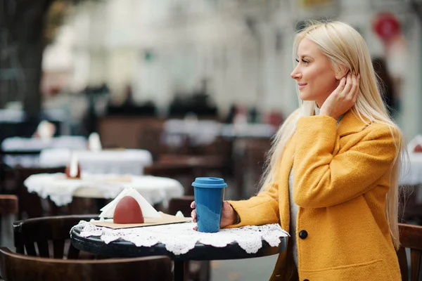 Una Joven Rubia Con Abrigo Amarillo Brillante Sienta Café Calle —  Fotos de Stock