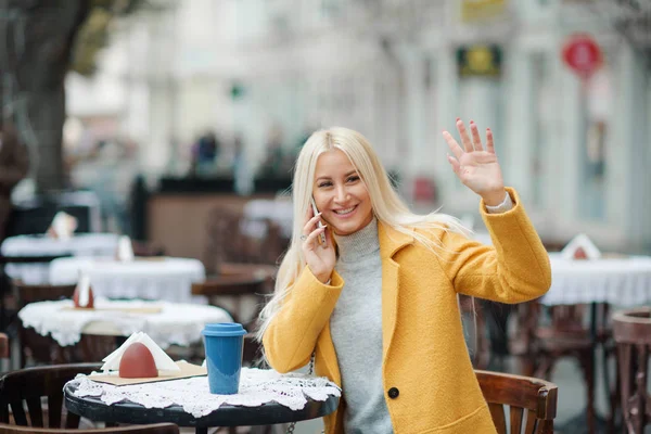 Eine Junge Blonde Frau Gelbem Hellem Mantel Sitzt Einem Straßencafé — Stockfoto