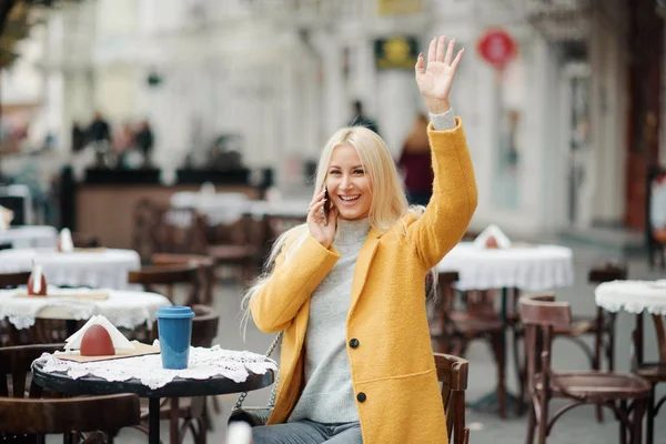 Eine Junge Blonde Frau Gelbem Hellem Mantel Sitzt Einem Straßencafé — Stockfoto