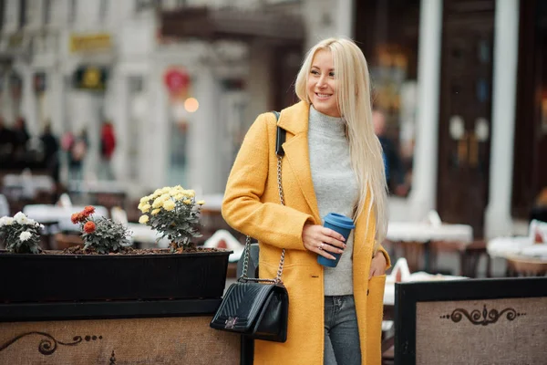 Una Joven Rubia Con Abrigo Amarillo Brillante Sienta Café Calle — Foto de Stock