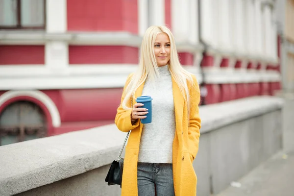 Stylische Junge Blonde Frau Leuchtend Gelbem Mantel Hält Coffee Fuß — Stockfoto