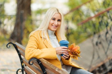 Bir parka gitmek için kahve içme genç şık sarışın kadın 