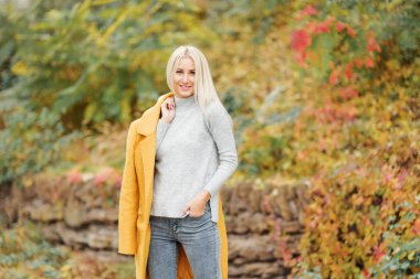 Moda yaşam tarzı gülen ve having fun şehir parkta güzel bir güneşli gün genç mutlu sarışın kadın portresi. parlak yeni renkler