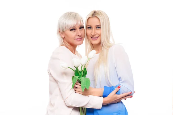Nastoletnia Blond Córka Dojrzałe Matki Bukietem Kwiatów Białym Tle Przytulanie — Zdjęcie stockowe