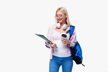 Gülümseyen genç kız öğrencinin sırt çantası içme ile kahve, kulaklık. Başlangıç, serbest meslek. Öğrenme yabancı dil online, sınava hazırlık