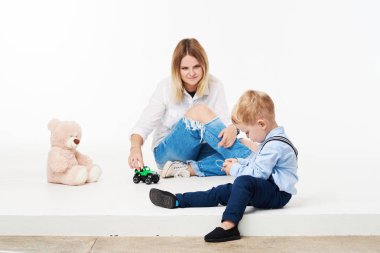 Mutlu genç anne onu yürümeye başlayan çocuk - annesi beyaz zemin üzerine sarılma oğlu - aile yaşam tarzı ile eğlenceli, annelik, sevgi ve ihale anlar kavramı olan