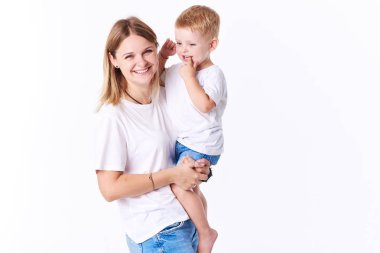 Güzel smimling yürümeye başlayan çocuk oğlu (gerçek aile) ile genç anne. Beyaz arka plan üzerinde izole. 