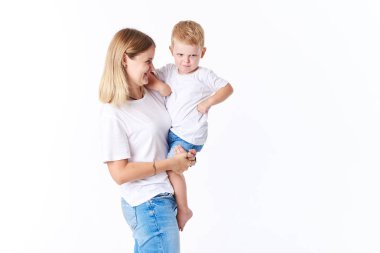 Güzel smimling yürümeye başlayan çocuk oğlu (gerçek aile) ile genç anne. Beyaz arka plan üzerinde izole. 