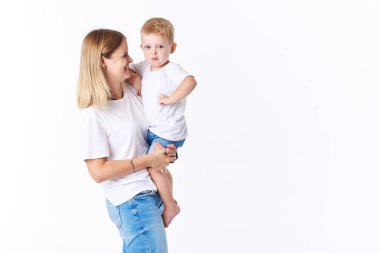 Güzel smimling yürümeye başlayan çocuk oğlu (gerçek aile) ile genç anne. Beyaz arka plan üzerinde izole. 