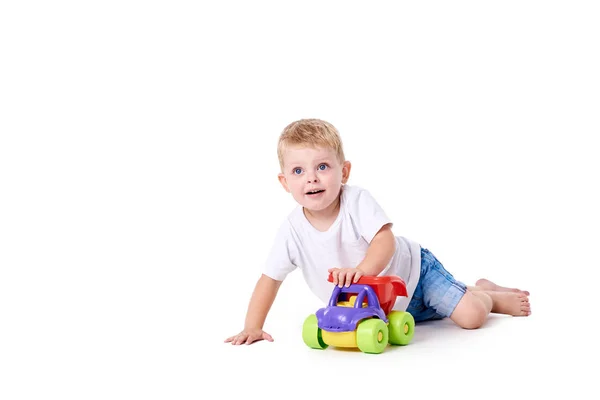 Niedlicher Junge Mit Spielzeugauto Auf Dem Boden Isoliert Auf Weiß — Stockfoto