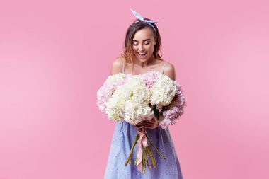 Retro yuvarlak gözlük mavi bahar buket pembe arka plan üzerinde izole kadınlar günü almak için heyecanlı olmak neşeli genç bayan. Metin için doğru uzay arıyor