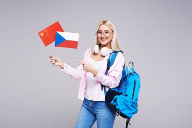 Eğitim, yabancı dil çevirmen, İngilizce, öğrenci - gülümseyen Çin ve Çek Cumhuriyeti bayrakları tutan Kulaklığımda sarışın kadın. Uzaktan eğitim