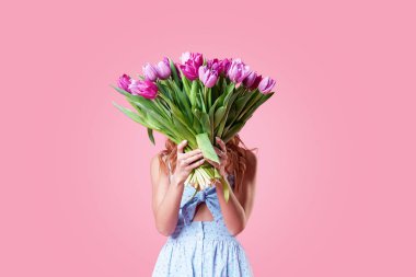 Buket pembe arka plan izole renkli bahar çiçek tutan genç mutlu gülümseyen Kızıl saçlı kadın. kadın 8 Mart gününde veya doğum günü onuruna şenlikli buket