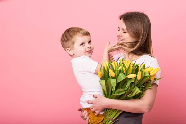 Jonge Moeder Knuffels Zijn Zoontje Zittend Vloer Tegen Een Roze — Stockfoto