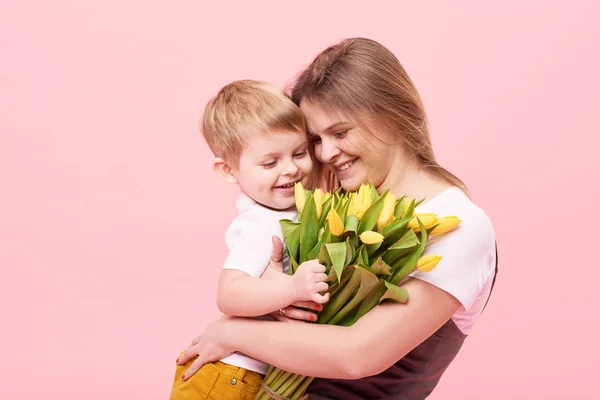 Jonge Moeder Knuffels Zijn Zoontje Zittend Vloer Tegen Een Roze — Stockfoto