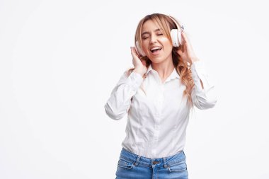 Kablosuz bağlantı. Genç güzel zevk kadın portre kulaklık ile beyaz arka plan dinleme müzik üzerinde izole poz. 
