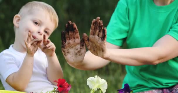 Mother and little blonde son show hands dirty with soil — Stock Video