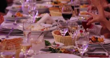 şarap bardakları tabaklar ve lezzetli yemek ve doğum günü elleri yakın görünümü kutlayan insanlar ile şenlikli masa koydu
