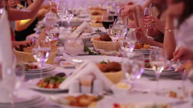 misafirler şenlikli masada oturan ve beyaz şarap yavaş hareket yakın görünümü ile doğum günü klink bardak kutluyor zevk