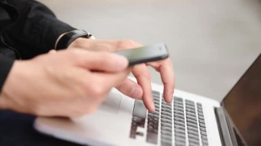 siyah gömlek iş korsanı dizüstü bilgisayar ve telefon aşırı yakın görünümü üzerinde çalışan ağ saldırı sorunlarını çözer