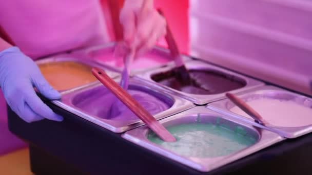 专业妇女手准备和混合明亮和五颜六色的结冰和玻璃美味的甜甜圈极端接近视图 — 图库视频影像