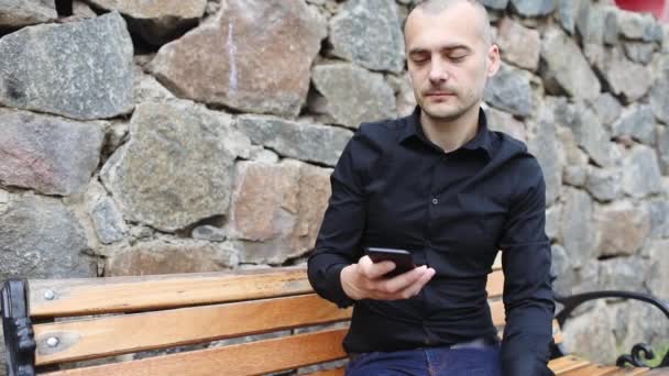 Yakışıklı Hacker Akıllı Telefon Tutar Kayalık Duvar Yavaş Hareket Bankta — Stok video