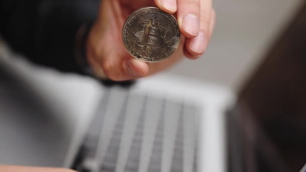 Hacker Hält Bitcoin Modell Mit Schwarzer Armbanduhr Auf Grauem Laptop — Stockvideo